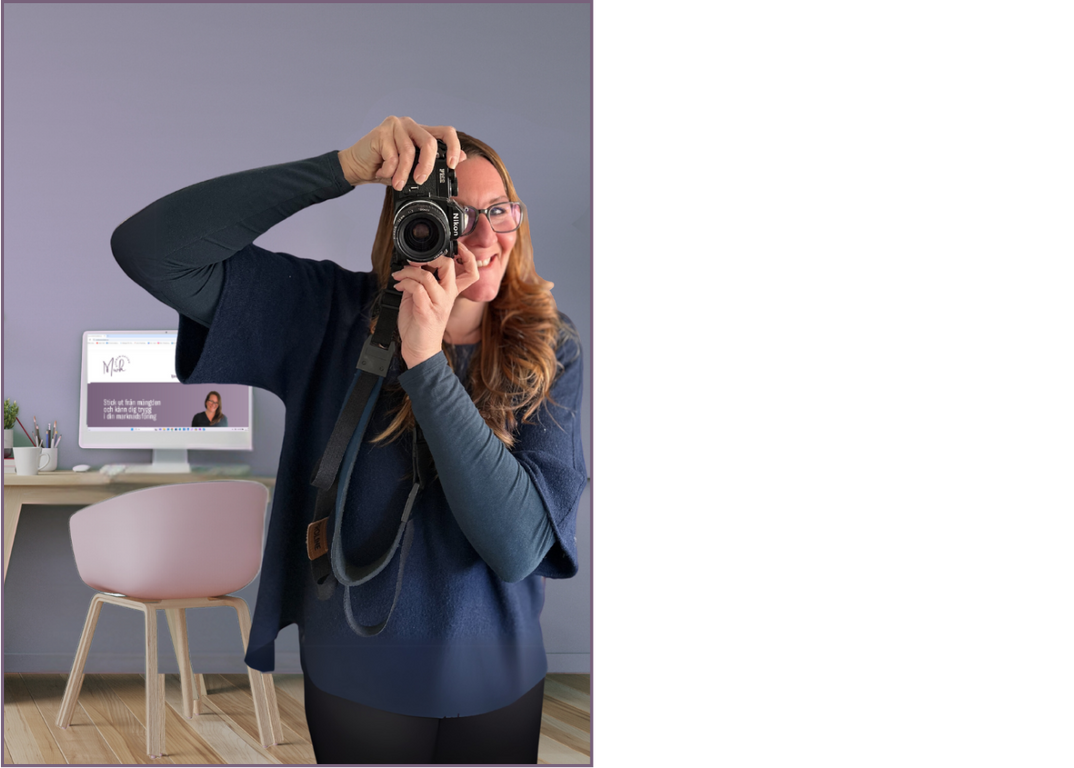 Kvinna som tar foto med en systemkamera vänd framåt, i bakgrunden syns ett skrivbord med en dator. ideoproduktion och fotografering för företag